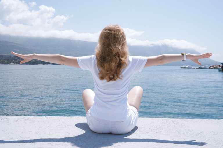 photo of woman sitting near body of water