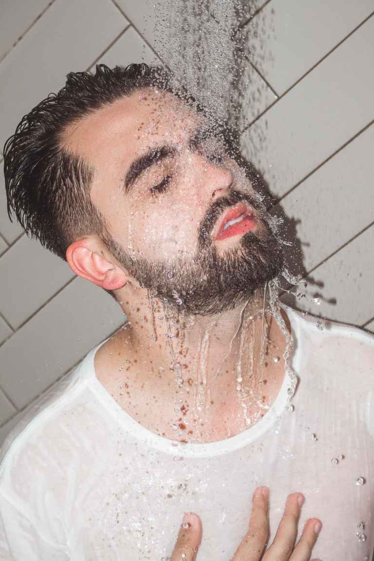 man in white crew neck shirt taking a shower